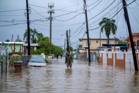 A member of the Puerto Rico National Guard wades through water in search for people to be rescued from flooded streets in the aftermath of Hurricane Fiona in Salinas, Puerto Rico September 19, 2022.  REUTERS/Ricardo Arduengo